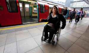 A woman in a manual wheelchair on a London Underground platform
